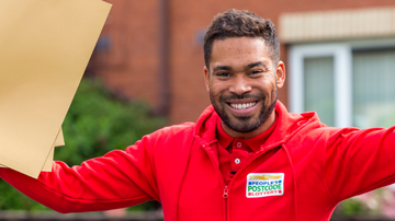 Danyl Johnson holding a big envelope and smiling